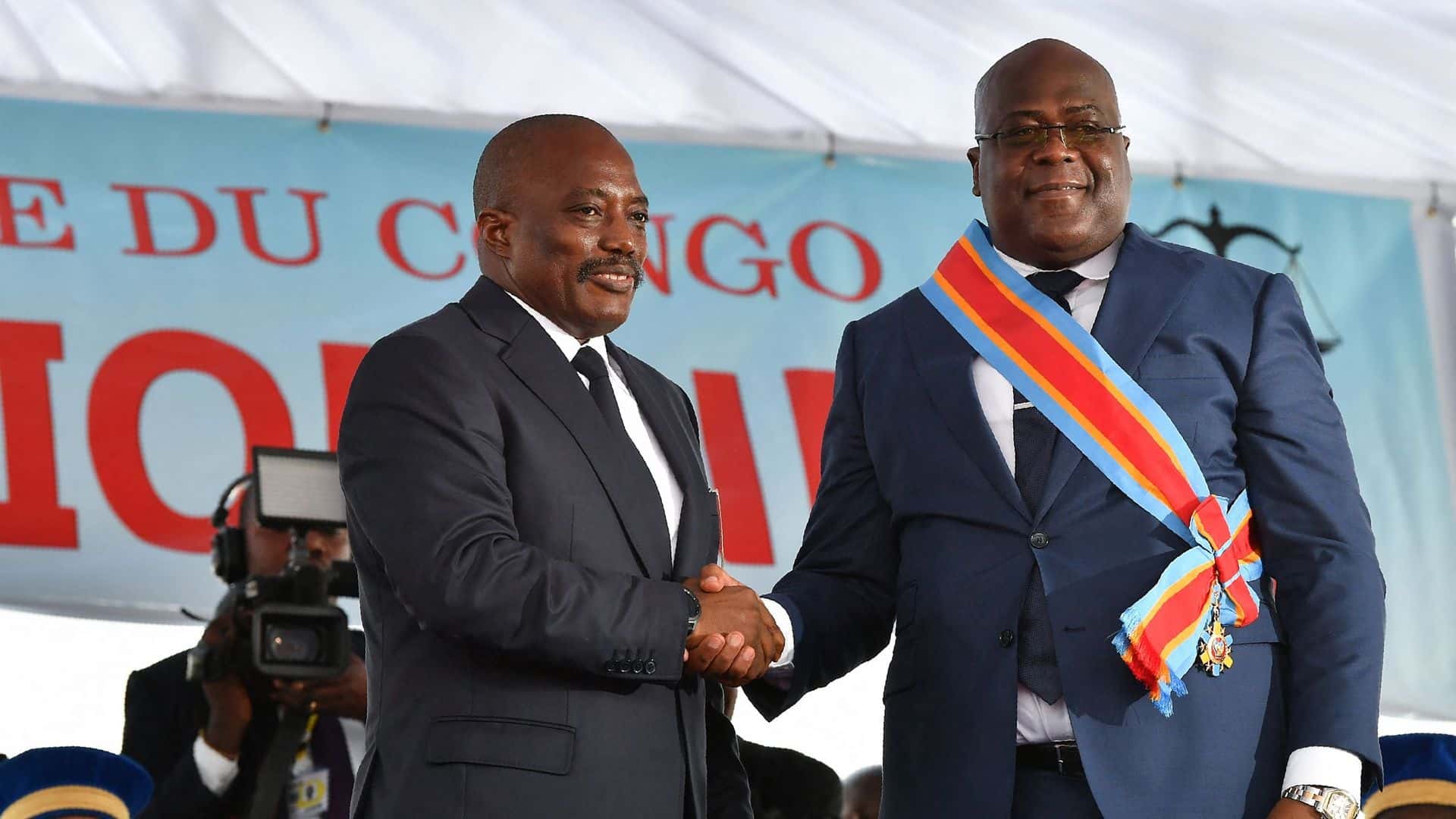 Le président sortant de la République démocratique du Congo, Joseph Kabila (à gauche), serre la main du nouveau président Félix Tshisekedi, le 24 janvier 2019, après son investiture à Kinshasa.