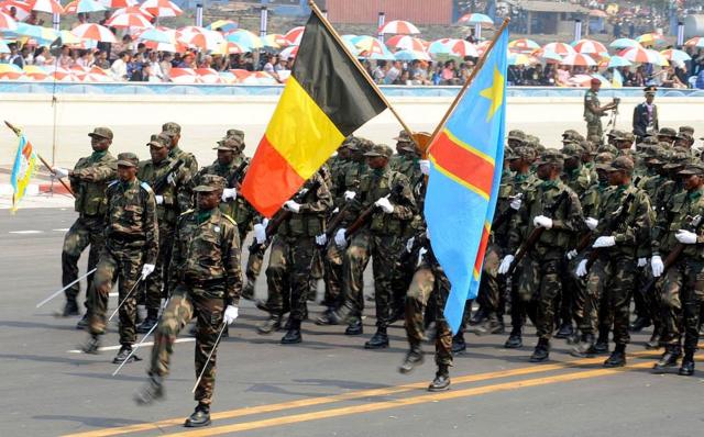 Soldats congolais lors d'un défilé, tenant le drapeau de la RDC et celui de la Belgique